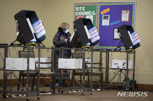 [액워스=AP/뉴시스] 5일 미국 연방상원 2명을 최종결정할 조지아주 결선투표일에 한 여성이 컴퓨터 스크린에 투표하고 있다.