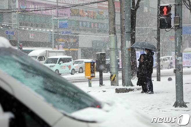 대설주의보가 내린 지난해 12월30일 오전 광주 북구 오치동 한 횡단보도 앞에서 우산을 쓴 시민들이 신호를 기다리고 있다.2020.12.30/뉴스1 © News1