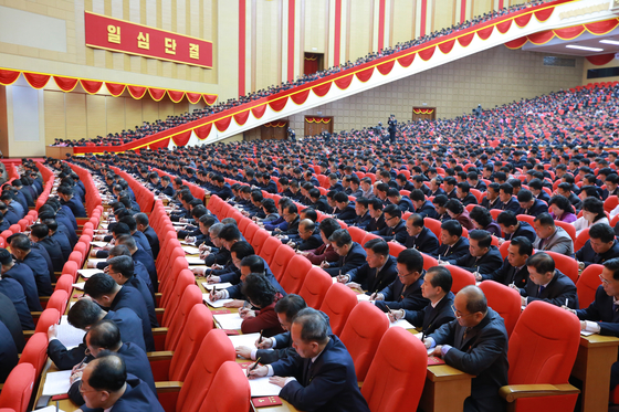 Delegates and participants of the 8th Party Congress jot down notes as Kim delivers his address at the event. Several thousand were packed into the auditorium for the congress, though not one wore a mask. [NEWS1]