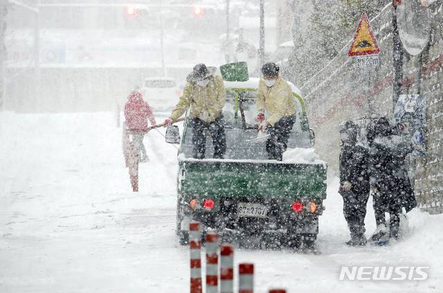 [광주=뉴시스] 변재훈 기자 = 광주·전남에 폭설이 내린 30일 오전 광주 북구 운암1동 일대에서 공무원들이 염화칼슘을 뿌리며 제설 작업을 하고 있다. (사진=광주 북구 제공) 2020.12.30. photo@newsis.com