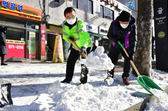 류경기 중랑구청장이 7일 오후 1시30분 주민들과 함께 제설작업을 하고 있다.