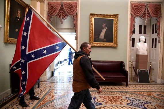 A supporter of President Donald Trump carries a Confederate battle flag on the second floor of the U.S. Capitol near the entrance to the Senate after breaching security defenses, in Washington, U.S., January 6, 2021. REUTERS/Mike Theiler TPX IMAGES OF THE DAY /REUTERS/뉴스1 /사진=뉴스1 외신화상