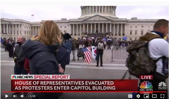 6일(현지시간) 워싱턴DC 미의회 의사당 난입시위 현장 생중계화면에 태극기와 성조기를 함께 든 시위자 모습이 포착됐다. 사진 방송화면 캡처