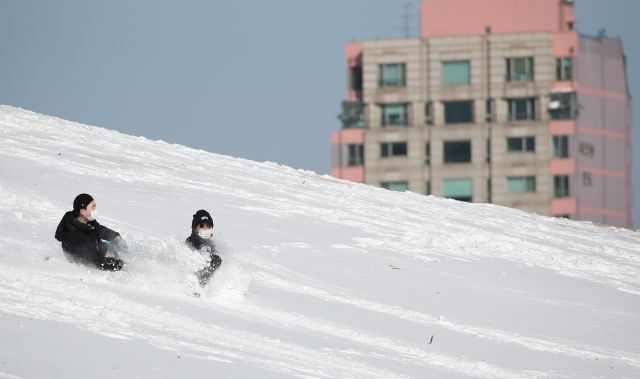 7일 오전 눈이 덮인 서울 송파구 올림픽공원을 찾은 시민들이 눈썰매를 즐기고 있다. 연합