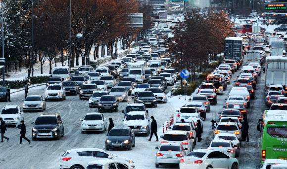 험난한 출근길 - 밤사이 많은 눈이 내린 7일 오전 경기도 수원시 영통구 광교로 중소기업지원센터 삼거리 부근이 정체되고 있다. 2021.1.7 연합뉴스