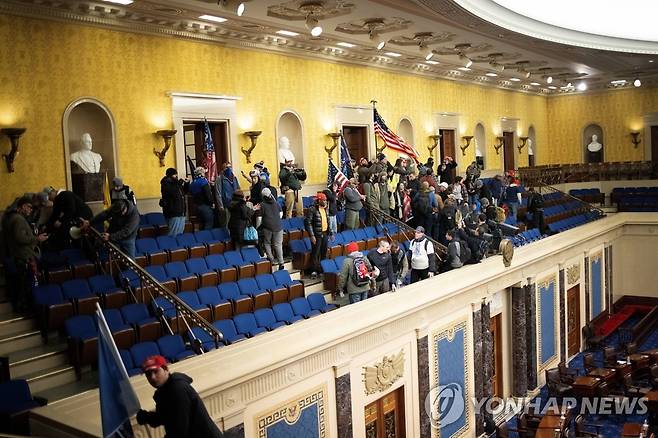 미 상원 본회의장 점거한 트럼프 지지 시위대 (워싱턴 AFP/게티이미지=연합뉴스) 도널드 트럼프 미국 대통령 지지 시위대가 6일(현지시간) 워싱턴DC 국회의사당 내 상원 본회의장을 점거해 농성을 벌이고 있다. 의회는 이날 조 바이든 대통령 당선인이 승리를 거둔 11ㆍ3 대선의 선거인단 투표 결과를 인증할 예정이었으나 시위대 난입으로 상ㆍ하원 합동회의는 1시간 만에 전격 중단됐다. 미국 민주주의의 상징인 의사당의 시위대 난입ㆍ점거 사태는 사상 초유의 일이다. sungok@yna.co.kr