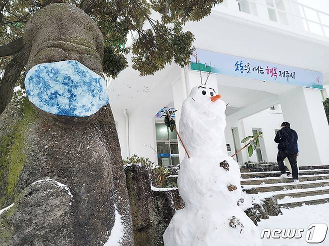 올 겨울 폭설과 한파가 최고조에 달한 8일 오전 제주시청 현관 앞에 마스크를 쓴 돌하르방과 눈사람 '올라프'가 서 있다.(독자 제공)2021.1.8/뉴스1 © News1 오미란 기자