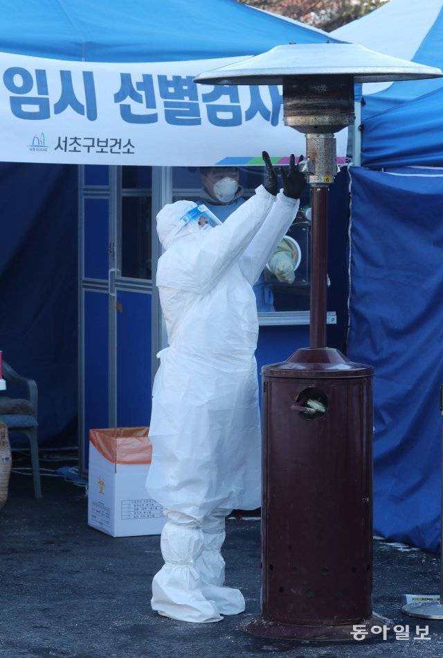 8일 오후 영하 18도 한파가 기승을 부리는 날씨속에 서울 서초구 고속터미널에 마련된 임시선별진료소에서 의료진과 구청 직원들이 추위에 핫팩과 히터에 의지한 채 검사를 하고 있다. 안철민 기자 acm08@donga.com