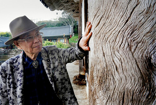 김영택 화백이 평소에 자주 찾는 전남 해남 미황사의 싸리나무 기둥을 쓰다듬고 있다.  김녕만 사진작가 촬영