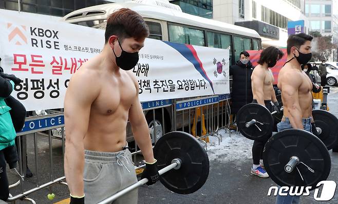 대한민국 기능성 피트니스 협회원들이 8일 서울 영등포구 더불어민주당사 앞에서 실내체육시설업 규제완화 촉구 퍼포먼스를 하고 있다. 2021.1.8/뉴스1 © News1 김명섭 기자