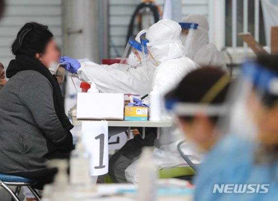 제주시보건소에 마련된 선별진료소에서 의료진들이 구슬땀을 흘리며 검체 채취에 집중하고 있다. [사진=뉴시스DB]