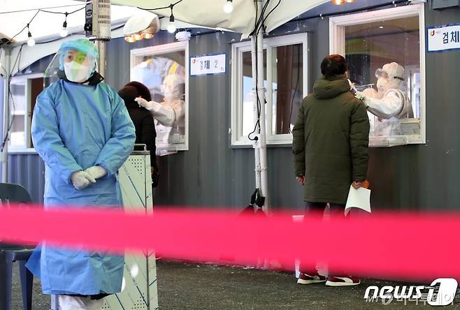 (서울=뉴스1) 오대일 기자 = '북극한파'가 이어진 8일 서울 용산구 서울역에 마련된 신종 코로나 바이러스 감염증(코로나19) 임시 선별진료소에서 의료진이 시민의 검체를 채취하고 있다. 진료소 창문에 전날 쌓인 눈이 녹아 흘러내리고 있다. 이날 0시 기준 국내 코로나19 신규 확진자는 674명으로 전일 870명 대비 196명 감소했다. 2021.1.8/뉴스1