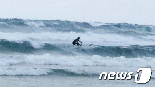 제주도 전 해상에 풍랑주의보가 발효 중이었던 지난 9일 오후 제주시 구좌읍 월정리 해변에서 한 관광객이 불법 서핑을 즐기고 있다.(제주해양경찰서 제공)© News1