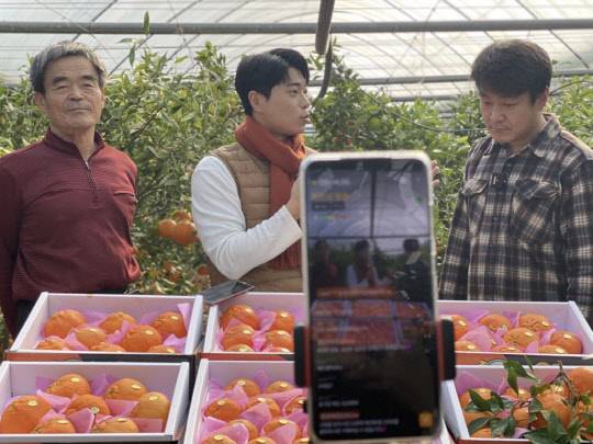 지난 6일 롯데백화점의 '생생라방' 방송에서 리포터와 함께 전남 나주 레드향 농장을 방문한 모습. <롯데쇼핑 제공>