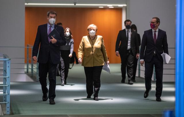 앙겔라 메르켈(가운데) 독일 총리가 독일 연방을 구성하는 지방정부 수장들과 코로나19 대응 조치를 논의하기 위한 회의를 마치고 이동하고 있다. 오른쪽은 미하엘 뮐러 베를린 시장, 왼쪽은 마르쿠스 죄더 바이에른 주총리. 베를린=PA 연합뉴스