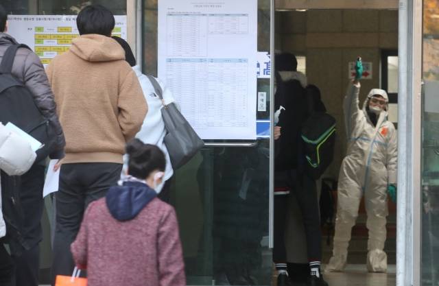 2021학년도 서울시 공립(국립, 사립) 중등교사, 보건사서영양전문상담특수(중등)교사 임용후보자 선정경쟁 제1차시험이 치러지는 지난해 11월 21일 오전 서울 용산구 용산고등학교에서 임용시험 참석 수험생들이 발열체크 및 거리두기 등 방역수칙 을 준수하며 입실하고 있다.