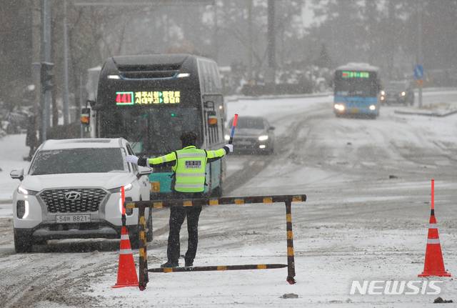 [제주=뉴시스]우장호 기자 = 제주 지역에 강추위 기승을 부리고 있는 7일 제주시 아라동 제주대학교 인근 사거리에서 교통경찰이 월동장구를 착용하지 않은 차량들의 산간도로 출입을 제한하고 있다. 2021.01.07. woo1223@newsis.com