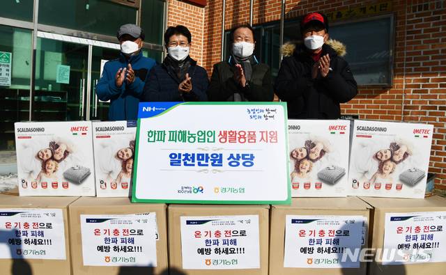 [수원=뉴시스] 정용왕 농협경기지역본부장(왼쪽 두번째)이 화성시 덕우마을을 방문해 생활용품을 전달하고 있다.(사진=경기농협제공) 2020.01.10.