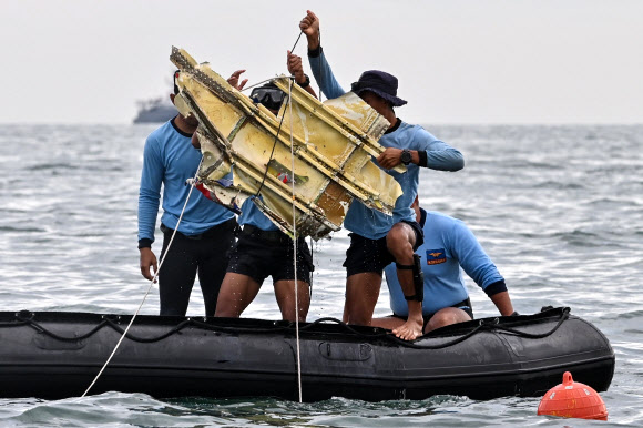 여객기 추락사고가 발생한 인도네시아 자카르타 앞바다에서 10일 수색대원들이 추락 여객기의 일부로 추정되는 파편을 들어올리고 있다.자카르타 AFP 연합뉴스