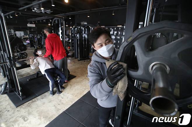 11일 오전 부산 부산진구의 한 헬스장에서 업주가 신종 코로나바이러스 감염증(코로나19)방역을 하고 있다. 이날 부산시는 헬스장 등 실내체육시설에 대해 오전5시부터 오후9시까지 영업을 허용하기로 했다. 2021.1.11/뉴스1 © News1 여주연 기자