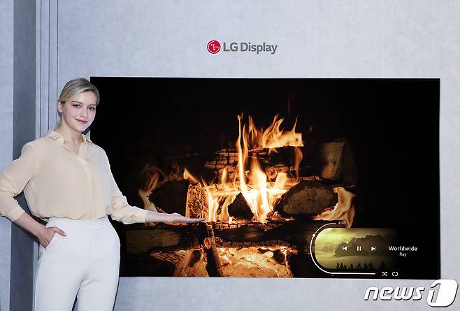 LG디스플레이 모델이 신규 OLED 소자가 적용된 77인치 차세대 OLED TV 패널을 소개하고 있다. (LG디스플레이 제공)© 뉴스1