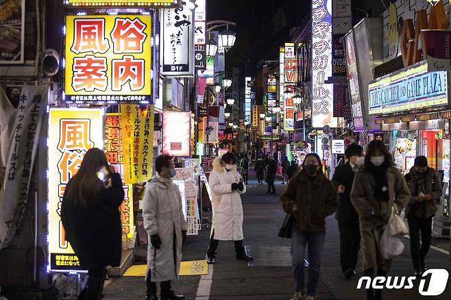 일본 정부가 수도권에 코로나19 관련 '긴급사태 선언'을 발령한 지난 8일 오후 도쿄도내 유흥가 신주쿠구 가부키정 골목을 마스크를 쓴 시민들이 지나가고 있다. © AFP=뉴스1