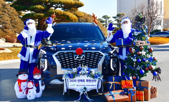 현대자동차가 지난해 12월 루돌프 장식을 한 파란 팰리세이드를 타고 소외 아동을 찾아가 선물을 전달하는 파란 산타 행사를 진행하는 모습. 사진 현대차