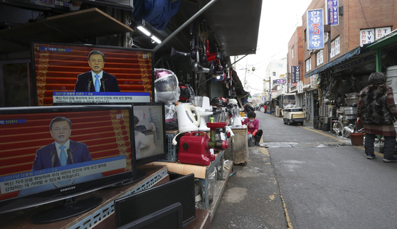 Television sets at a thrift shop in Jungang Market in Jung District, central Seoul, show President Moon Jae-in delivering a New Year address Monday. [YONHAP]