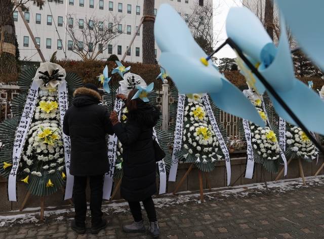 대한아동학대방지협회관계자들이 11일 오전 서울 양천구 남부지방검찰청과 남부지방법원 앞에 정인이 양부모에 대한 엄벌을 촉구하며 근조화환과 바람개비를 설치하고 있다. 연합뉴스