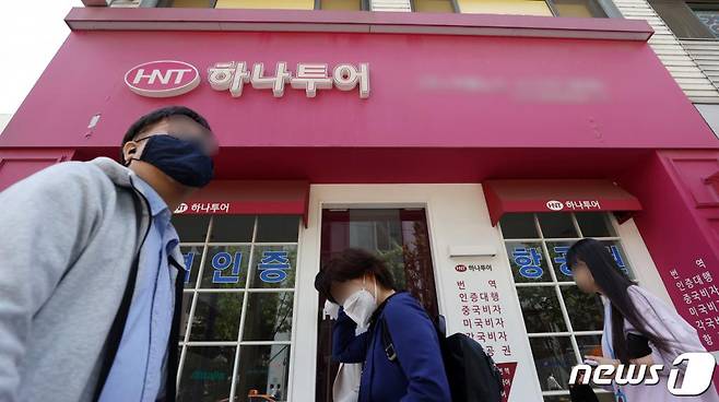 지난 5월 서울 종로구에 위치한 하나투어 대리점 간판을 단 한 소규모 여행사의 불이 꺼진 가운데 시민들이 지나는 모습. /사진=뉴스1