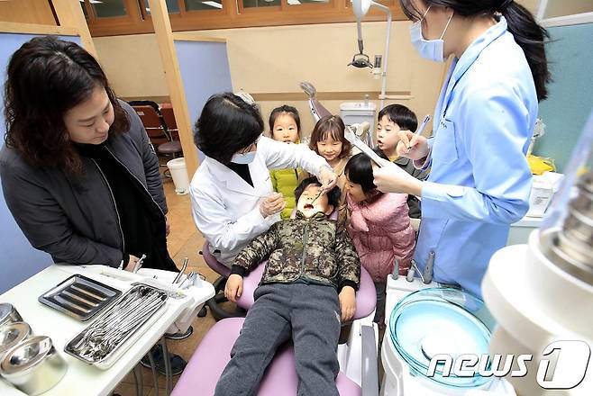 광주 북구보건소 치과실에서 건강한 치아와 구강질환 예방을 위한 아동치과 주치의사업에 참가한 아이들이 의사에게 구강검사를 받고 있다. /뉴스1 © News1