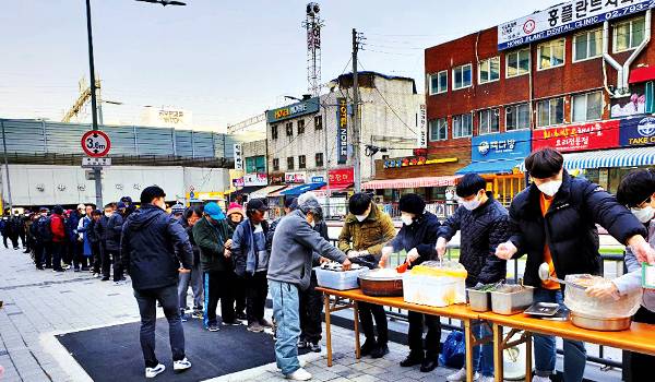 서울역노숙인자활센터 직원과 후원자들이 지난 주말 서울 지하철 신용산역 앞에서 노숙인들에게 식사를 제공하고 있다.                     서울역노숙인자활센터 제공