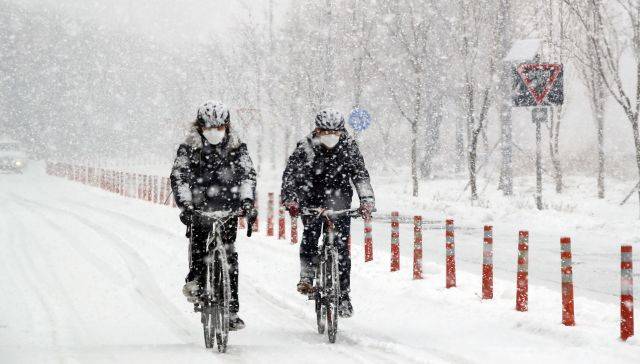 12일 오후 서울 한강공원에서 시민들이 눈을 맞으며 자전거를 타고 있다. 연합뉴스