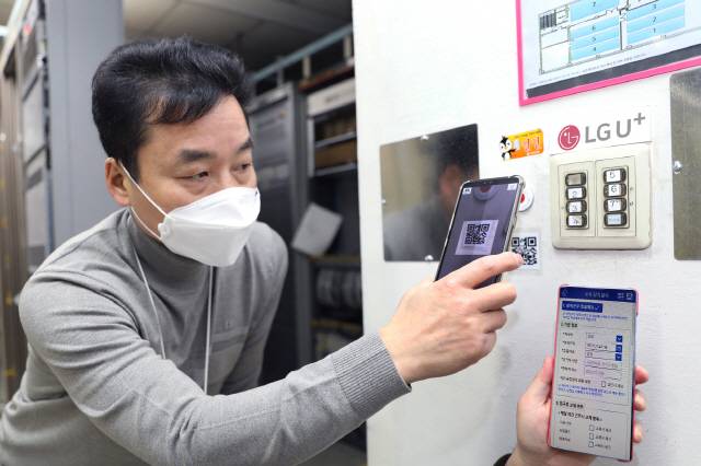 LG유플러스 직원이 12일 모바일 앱 ‘국사 당직일지’를 이용하기 위해 스마트폰으로 큐알코드를 스캔하고 있다. LG유플러스는 네트워크 현장에서 수기로 작성하던 업무정보의 디지털 전환과 로봇 프로세스 자동화(RPA) 도입으로 단순·반복업무에 소요되던 시간을 연간 11만 시간 줄였다고 밝혔다./사진제공=LG유플러스
