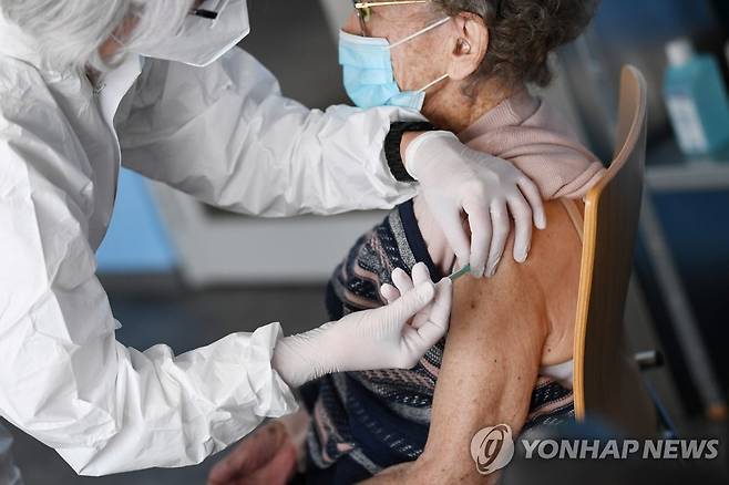 독일 바이에른주 백신접종센터에서 100세 할머니에게 코로나19 백신을 접종 중인 의료진.[로이터=연합뉴스]