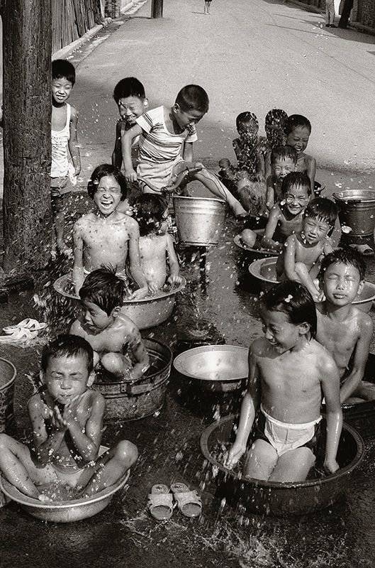 사진기자였다면 누구나 탐낼만한 장면입니다. 어느 무더운 여름날 대야 속에서 어린이들이 대야 속에 들어가 물놀이를 하고 있네요! 아이들의 표정 하나 하나가 살아 있습니다.