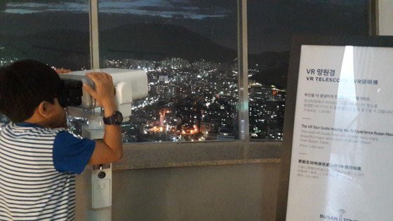 부산타워 전망대에서 한 관광객이 VR망원경으로 부산 야경을 보고 있다. 이은지 기자