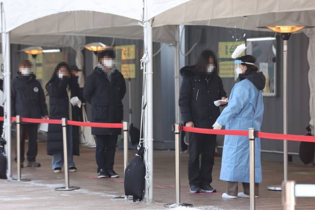 신종 코로나바이러스 감염증(코로나19) 확진자 수가 이틀 연속 500명대를 유지하며 더딘 감소세를 보이고 있는 13일 오전 서울시청 앞 마련된 임시선별진료소에서 검사를 받기 위한 시민들이 줄을 서 있다. /연합뉴스