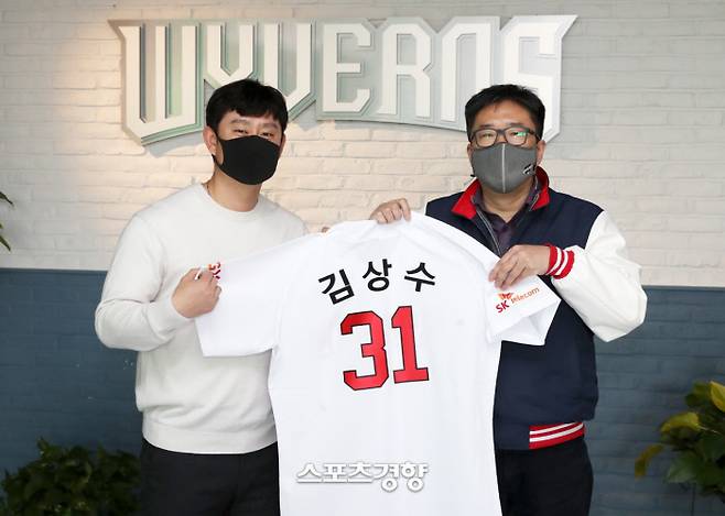 투수 김상수가 13일 사인 앤 트레이드로 SK로 이적한 뒤 류선규 단장과 기념촬영을 하고 있다. | SK 와이번스 제공