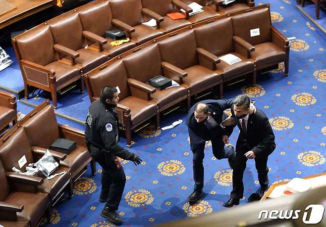 미국 연방의회 의사당 난입 당시 한 의원이 경호원과 함께 건물을 빠져나가고 있다. © AFP=뉴스1