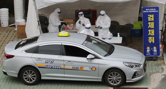 지난 11일 부산지역 택시 기사들이 부산아시아드주경기장 주차장에 설치된 이동 선별검사소에서 드라이브스루 방식으로 코로나19 진단검사를 위한 검체를 채취하고 있다. 송봉근 기자