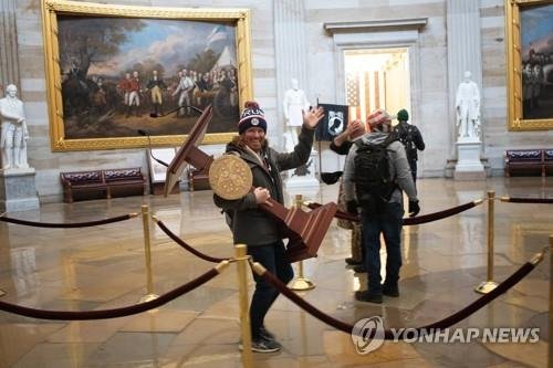 낸시 펠로시 의장 연설대 가져가는 등 의회 난입 혐의로 체포된 애덤 존슨. [AFP=연합뉴스]