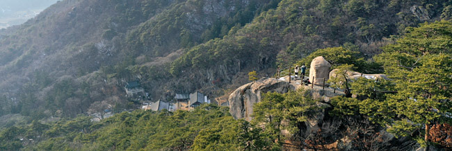 공덕산 자락에 아슬아슬 벼랑을 이룬 너럭바위에 올라앉은 사불암(四佛巖). 사방에 불상이 새겨진 바위가 비단에 싸여 하늘에서 내려왔다는 이야기가 전해지는 곳이다. 사불암 너머 저 아래로 암자 윤필암이 내려다보인다. 윤필암에는 불상 대신 유리창 밖으로 올려다보이는 사불암을 모신 법당 사불전이 있다.
