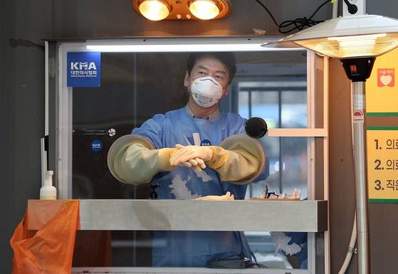 국민의당 안철수 대표가 15일 서울광장에 마련된 임시 선별검사소에서 의료 자원봉사에 나서 검체채취를 준비하고 있다. [출처-연합뉴스]