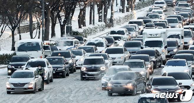 지난 7일 오전 경기 수원시 영통구 광교로에서 출근 차량들이 밤사이 내린 눈으로 서행하고 있다. 2021.1.7/뉴스1 © News1 조태형 기자