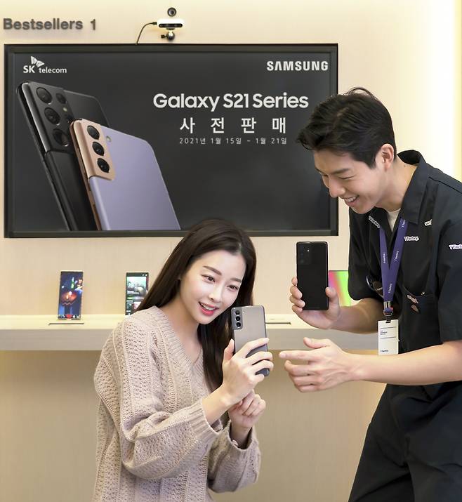 A customer looks at a Galaxy S21 device at an SK Telecom shop in Seoul on Friday. (SK Telecom)