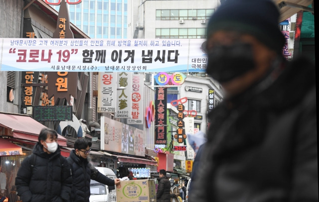 신종 코로나바이러스 감염증(코로나19) 확산으로 피해를 본 소상공인에게 최대 300만 원의 '버팀목자금'(3차 재난지원금) 지급이 시작된 11일 서울 남대문시장에 '코로나19 우리 함께 이겨 냅시다'라고 쓰인 현수막이 걸려 있다.