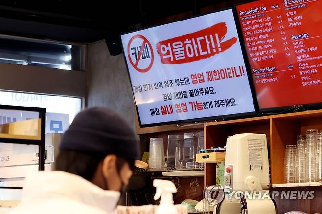 카페에 띄워진 영업 제한 비판 문구 1월 6일 오후 서울 관악구의 한 카페 메뉴전광판에 신종 코로나바이러스 감염증(코로나19) 확산 예방을 위한 정부의 '카페 홀 이용금지' 조치를 비판하는 문구가 띄워져 있다. [연합뉴스 자료사진]
