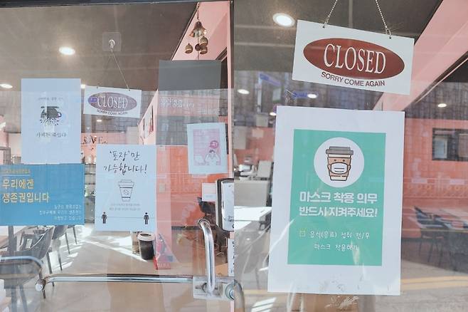 (왼쪽) 지난 6일 서울시 금천구의 한 카페가 정부의 영업제한 조치에 반발해 "카페는 죽었다"는 항의 포스터를 붙인 모습. (오른쪽) 두 달 만에 영업 제한 조치가 완화되면서 해당 카페가 항의 포스터를 내리고 영업을 준비하고 있다. /사진=김나현 기자.