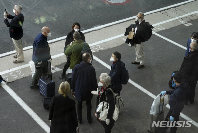 [우한=AP/뉴시스]세계보건기구(WHO) 조사단이 14일 중국 중부 후베이성 우한 공항에 도착해 입국 수속을 마치고 모여 있다. 다국적 전문가로 구성된 WHO 조사단은 우한에 한 달가량 머물면서, 지난 2019년 말 코로나19가 집단 발병했던 화난 수산시장 등을 조사한다. 2021.01.14.